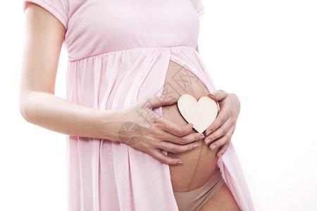 孕妇把心放在她的肚子上图片