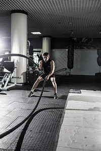 有吸引力的肌肉人用重绳子工作身穿运动服的英背景图片