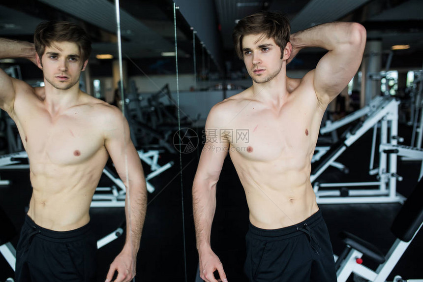 有吸引力的肌肉男在镜子中欣赏他的肌肉并检查锻炼结果夏季图片
