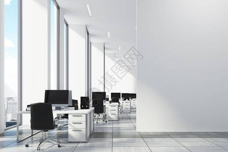 白色的开放式办公室有狭窄的高窗户白色的电脑桌和黑色的办公椅图片