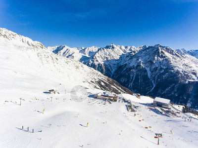 对阿尔卑斯山滑雪胜地滑雪电梯和在斜坡上滑雪的人图片