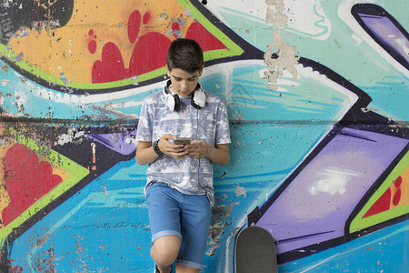 儿童使用手机和滑板街图片