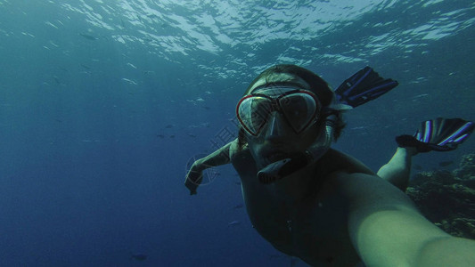 浮潜戴着面具和管子的家伙漂浮在海里图片