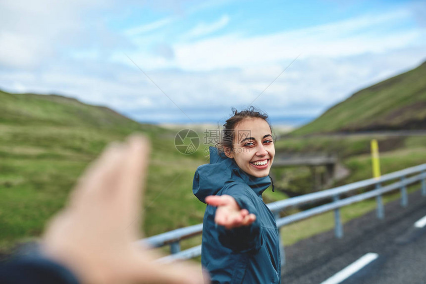 笑着的小女孩伸手要求跟随她走山路冰岛西佛尔图片