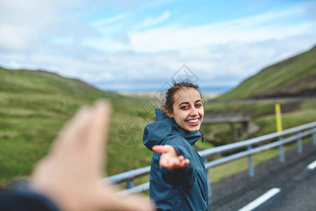 笑着的小女孩伸手要求跟随她走山路冰岛西佛尔图片
