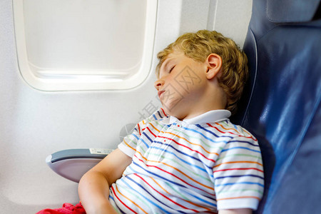 小男孩在飞机上长途飞行时睡觉图片
