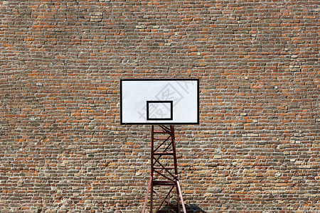 砖墙背景上运动场上的篮球盾牌图片