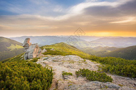 满是日落的金色光芒的云层下的落岩山脉夏季山地景观h图片