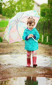 孩子在雨中带着伞图片