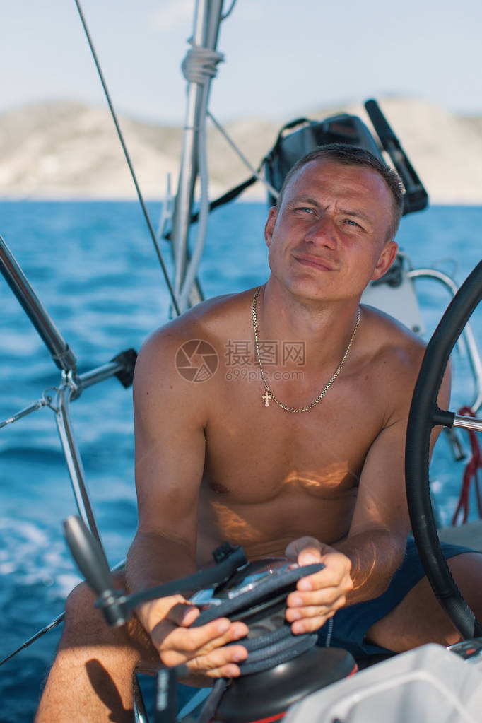 掌舵帆船的年轻人图片