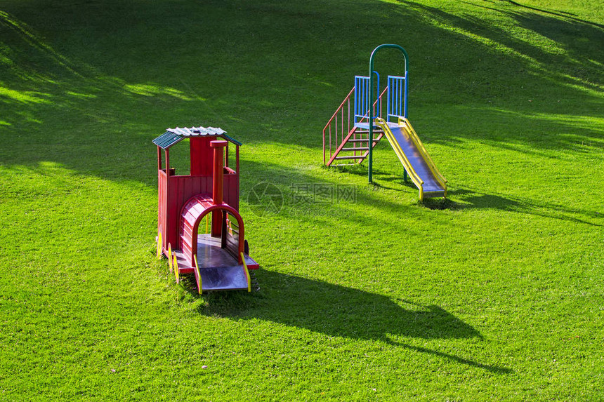 公园里儿童的多彩游乐场童年设备和对象的概念太阳照图片