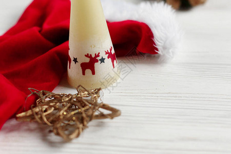 圣诞老人帽子与鹿和金星的蜡烛在白色图片