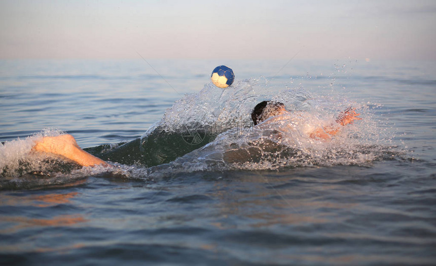 小男孩夏天在海里打水球图片