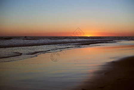 海水沙滩上湿沙子日落橙色全景的图片