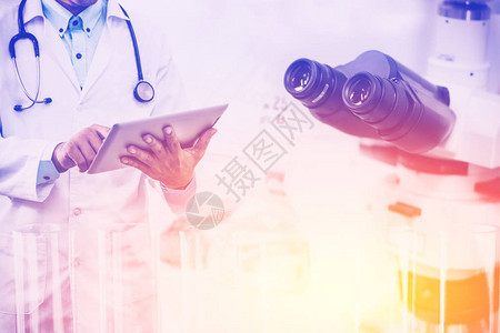 医学科研究与发展理念医生在实验室背景下手持带科学仪器显微镜和化学试图片