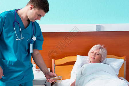 使用医院病房里的特殊控制台调节女病人的病床图片