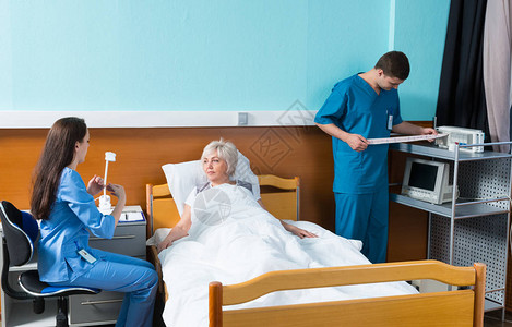 护士和医生在病房的床上对一名病人进行测试图片