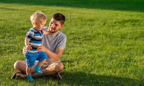快乐的父亲和儿子在草原上图片