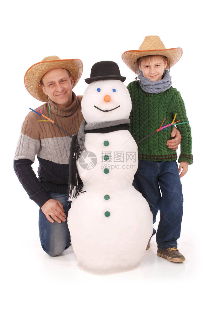 父亲和儿子与雪人围巾和帽图片