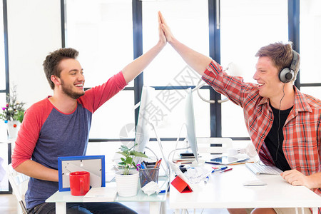 两个在办公室的年轻男子鼓掌拍手作图片