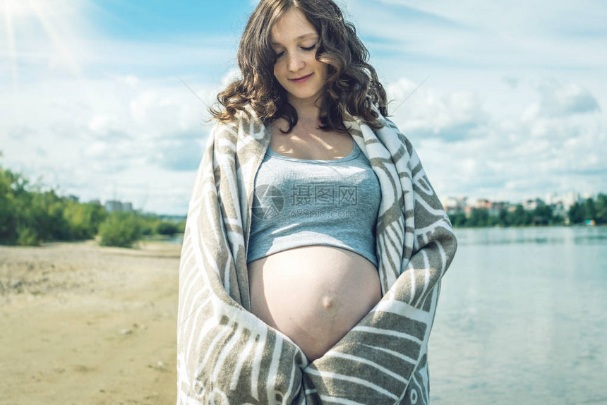 孕妇走在河岸上裹着毯子图片