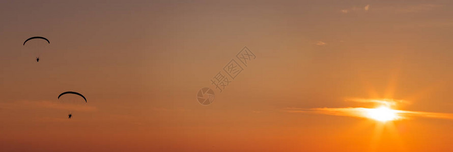 在美丽的日落中滑翔伞与准图片