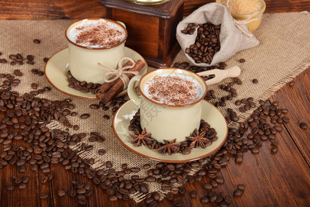 含香草和咖啡谷物的棕色陶瓷杯中含有牛奶和巧克图片