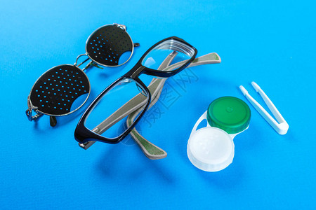 一套视觉配件针孔眼镜带容器的镜片和视力眼镜一副带反射的医用针孔眼镜医学背景图片