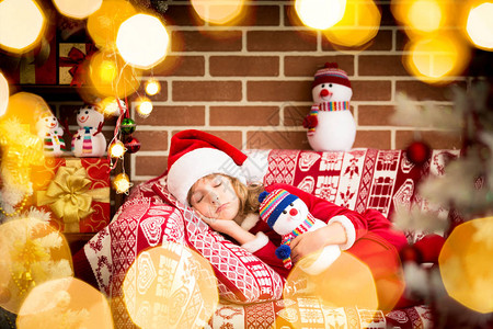 穿着圣诞老人服装的小女孩睡在Fir图片