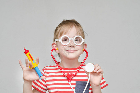 玩医生的可爱男孩玩具针筒眼镜背景图片
