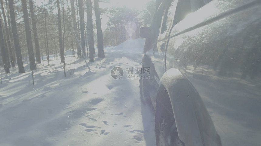 车在冬季森林路上行驶一辆汽车在树间积雪图片