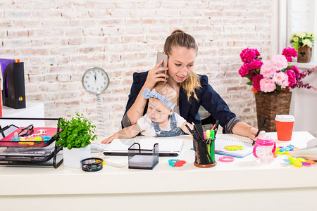 家族企业远程办公女商人和带孩子的母亲正在打电话在工作场所图片