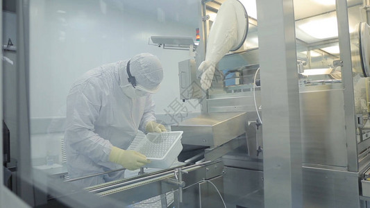 医药行业男厂工人检查药厂丸包装质量用于创建药品包装和灌装的自动胶带图片