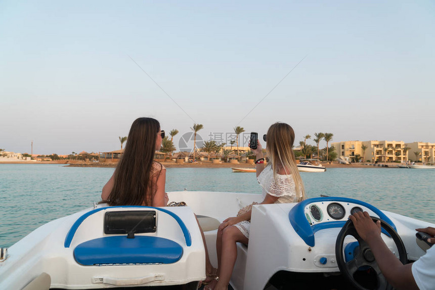 女孩在ElGouna市的通道上乘船并图片