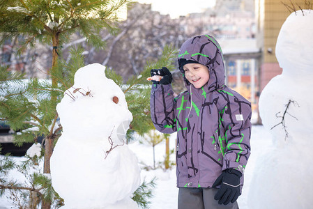 有趣的小男孩堆雪人图片