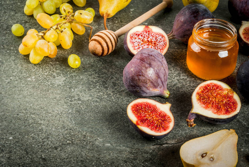 黑石桌上有蜂蜜的秋季水果胶片梨子葡萄图片