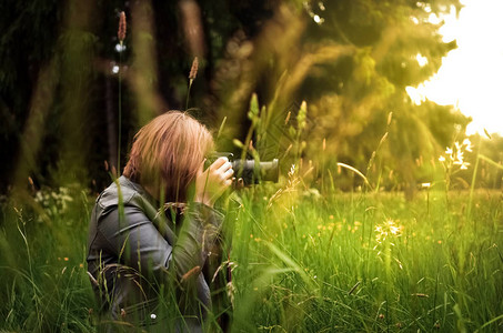 在绿草地户外拍摄妇女摄影镜头在绿图片