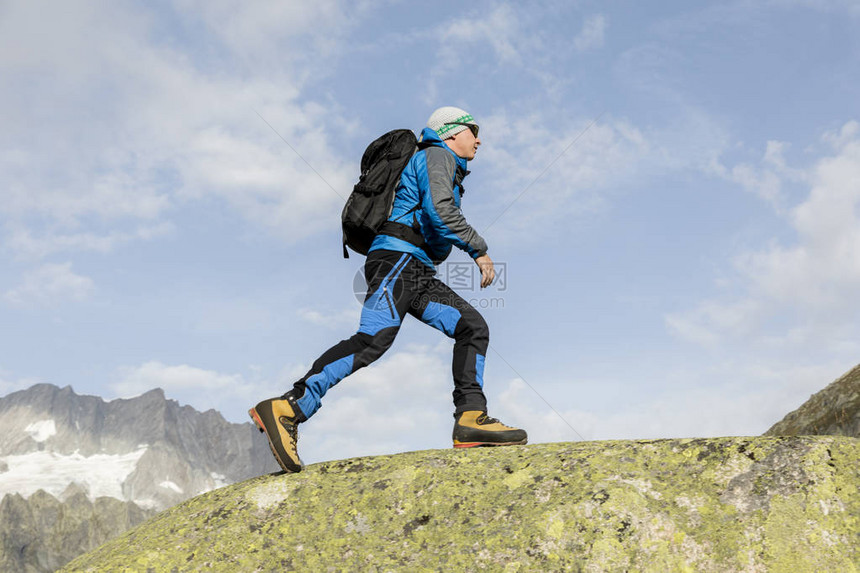 一位型登山者在瑞士阿尔卑斯山攀登山顶图片
