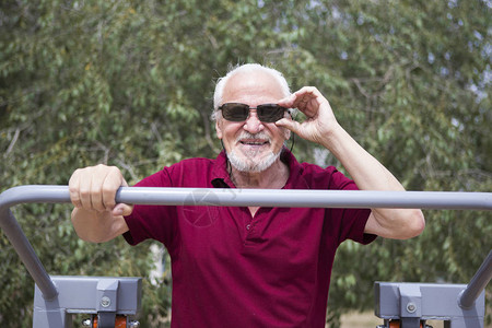 有吸引力的老人在露天城市训练运动器材每个人的健康生活方式和运动训练的可及概念公共场所背景图片