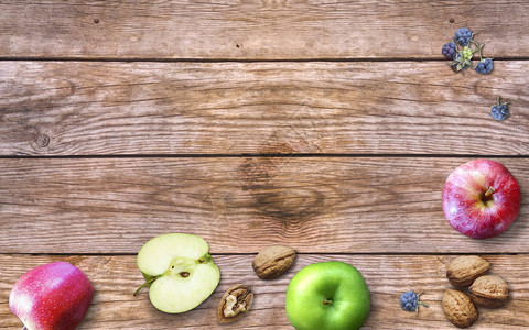 与苹果核桃和旧木背景上的浆果搭配时令浆果和水果非凡的收获概念图片
