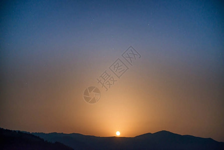 月亮在夜空中升起山背景图片