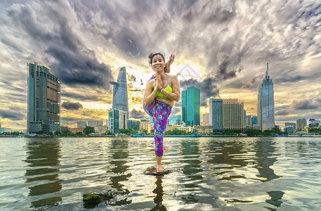 穿着运动胸围和短裤户外日落城市河流边的市内有吸引力背景图片