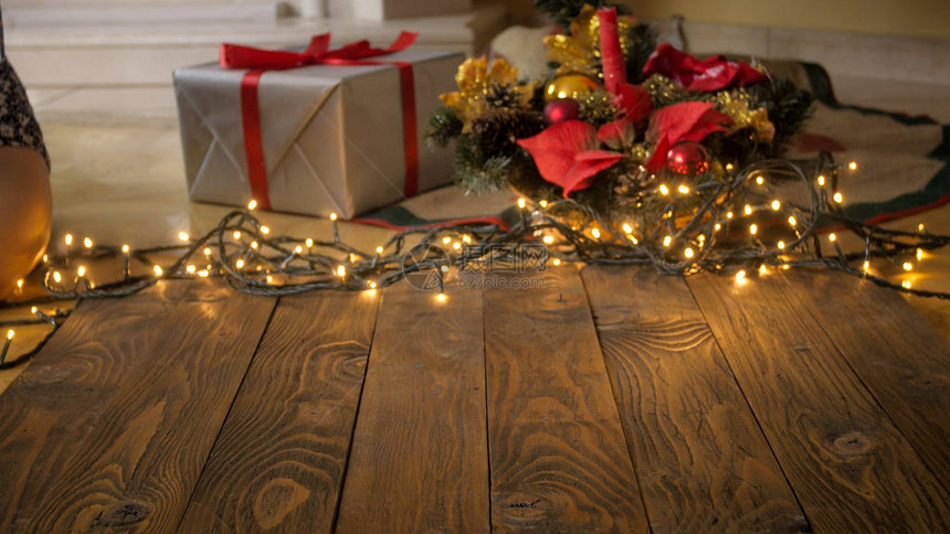 空木桌与礼物发光灯和圣诞树的对比鲜明的形象图片