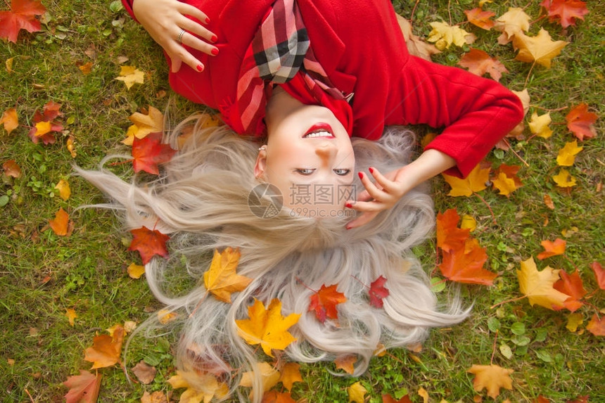 漂亮微笑的年轻金发快乐女人穿着红色温暖的外套图片