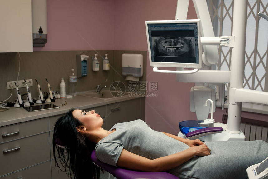 女病人躺在牙科椅上图片