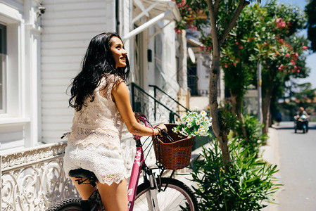 炎热带夏季背景妇女骑粉色自行车骑图片