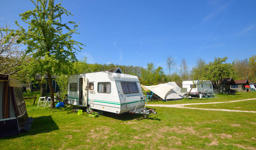 露营地绿色草坪上的白色大篷车拖晴天春天的风景欧洲生活方式旅行生态旅游公路旅行旅程假期娱乐交通图片