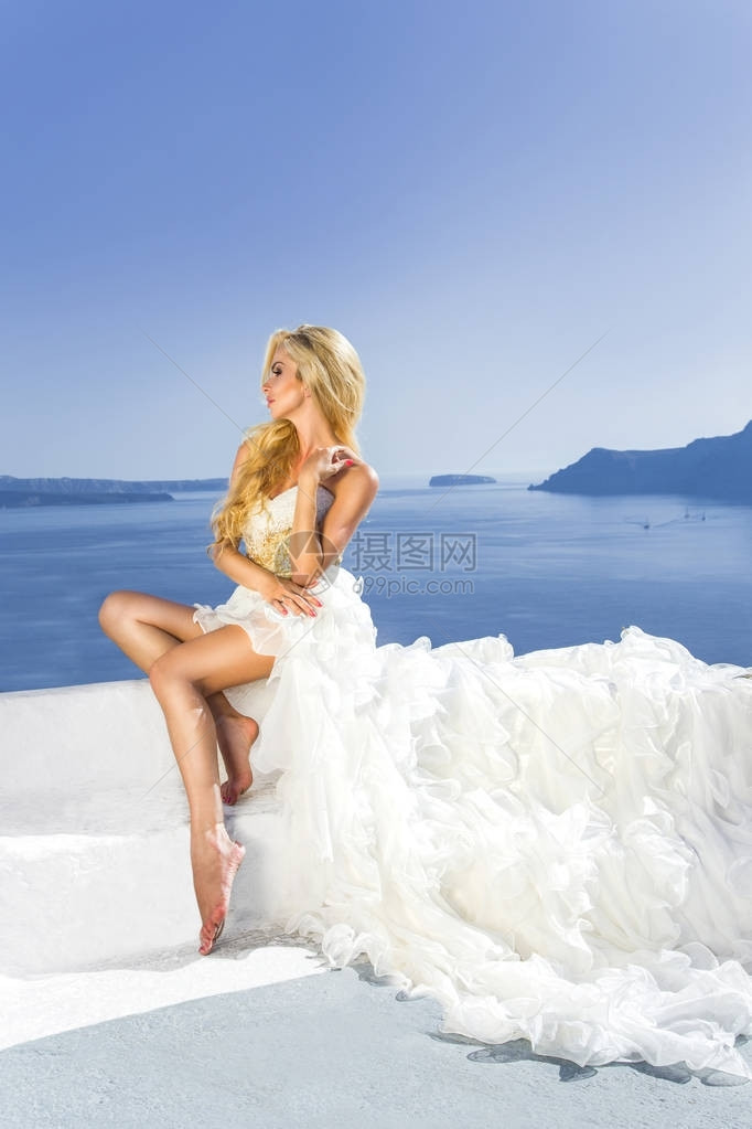 希腊圣托里尼岛外穿着令人惊艳婚纱的金碧新娘女模特儿在希腊图片