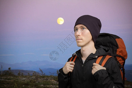 山上带着背包的年轻远足者月亮图片