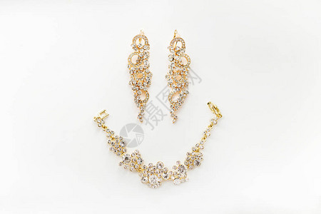 白色背景的黄金女珠宝耳环和手镯上写着图片